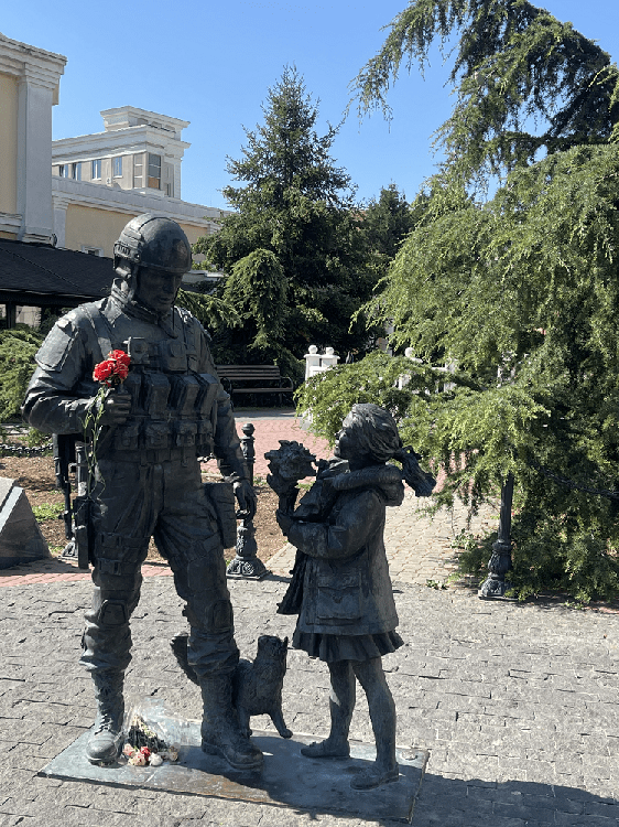 Lille pige giver soldat en blomst